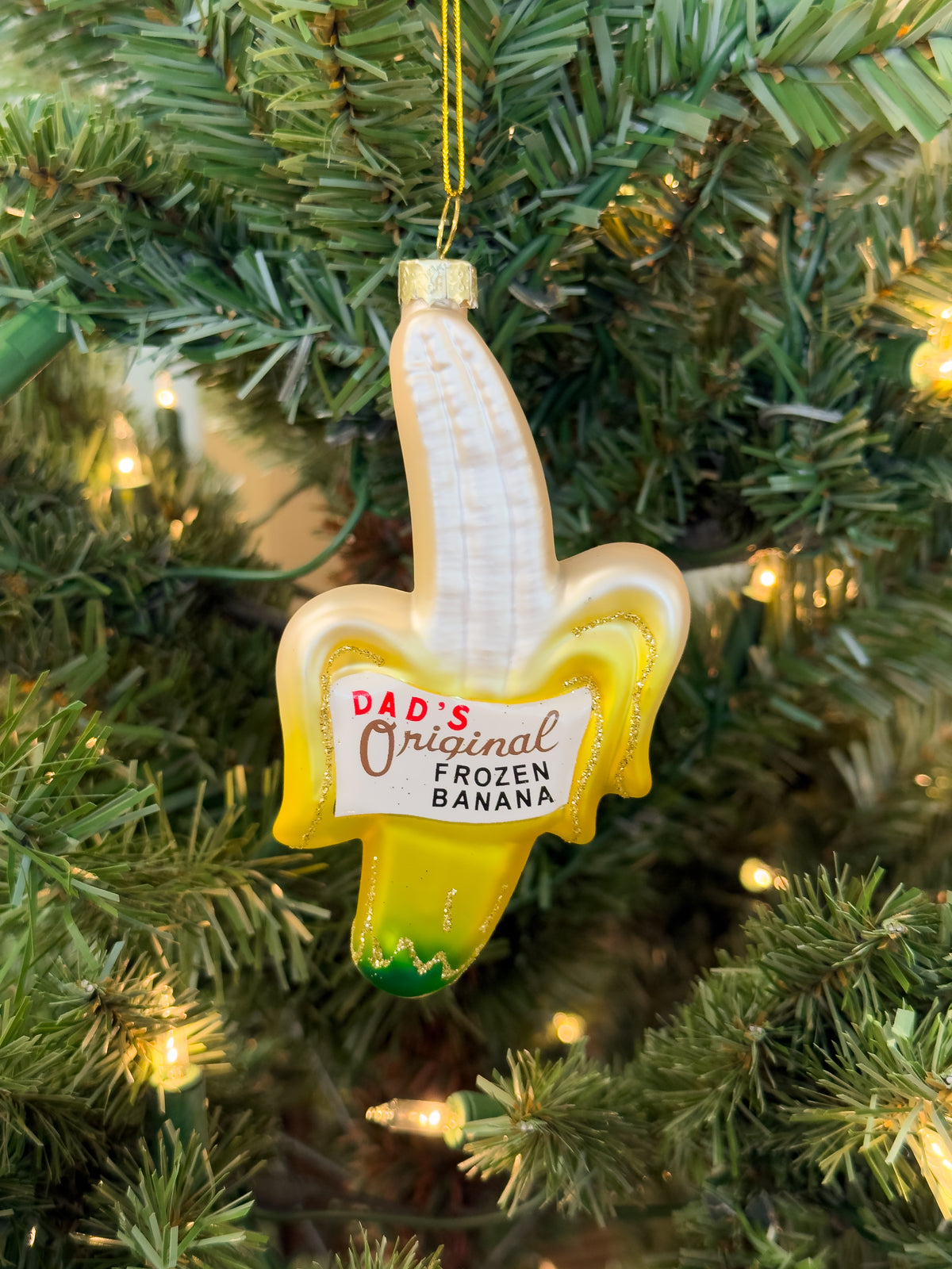 Hand-blown glass ornament shaped like a peeled banana with a “Dad’s Original Frozen Banana” label